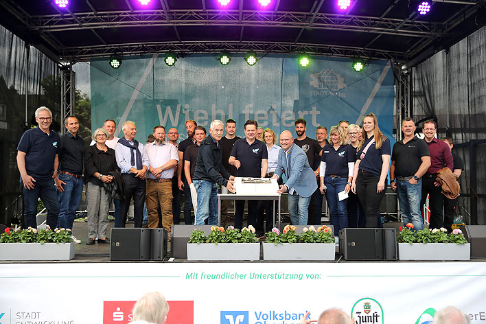 Gruppenbild mit Themen-Torte in der Mitte: Der Brgermeister dankte allen am Bau Beteiligten und den Wiehlerinnen und Wiehlern fr deren Mitwirkung.